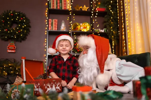 Liten pojke besöker jultomten gör en önskan medan blunda. God jul. Semester — Stockfoto