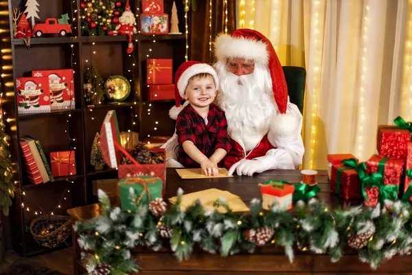 Petit garçon rend visite au Père Noël l'aide à ouvrir des enveloppes avec des lettres de Noël. Concept de vacances — Photo