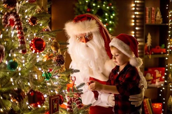 Jultomten dekorera julgran med liten pojke assistent hemma. Nytt år, lycklig barndom — Stockfoto