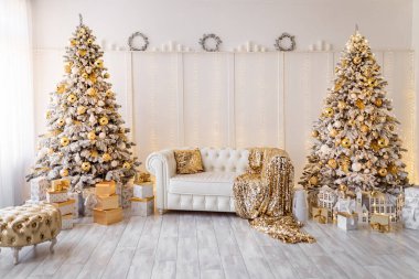 Beyaz, modern, yeni yıl ağaçlarıyla süslenmiş bir iç mekan. Altın puf, tekstil, hediyeler 