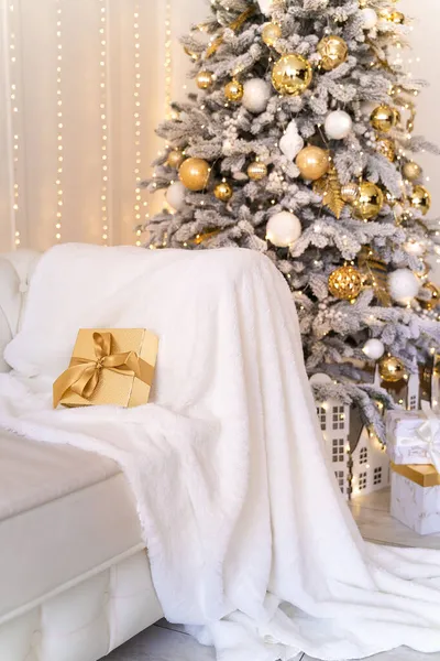 A karácsonyi és újévi dekoráció. Karácsonyfa játékokkal és ajándékokkal. nappali kényelmes kanapéval — Stock Fotó