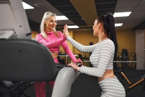 Kobiecy trener personalny wspiera klientkę po bieganiu na bieżni w siłowni. Zdrowy styl życia — Zdjęcie stockowe