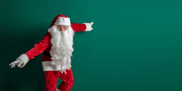 Emotionaler Schauspieler im Kostüm des Weihnachtsmannes mit langen Bartgesten und Posen auf grünem Hintergrund — Stockfoto