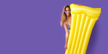 Sarı şişme şilteli, mor stüdyo geçmişli, bikinili, gülen kız ankete gidiyor.