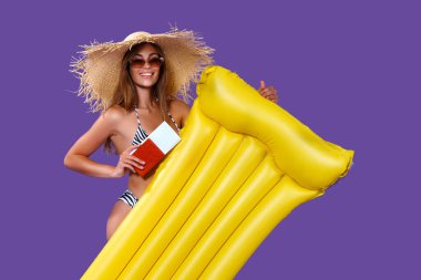 Bikinili mutlu kız seyahate çıkıyor. Sarı şişme şilteli, biletli, pasaportlu.