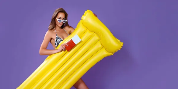 Beautiful girl ready to summer vacations shows tickets, passport while holding inflatable mattress — Stock Photo, Image