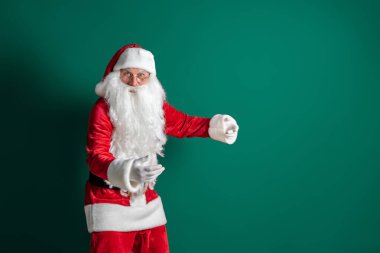 Noel Baba kostümlü, yeşil stüdyo arka planında uzun sakallı duygusal erkek oyuncu.