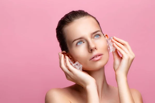 Pretty young woman with healthy clean fresh skin applies Ice cubes on face. Skincare concept — Stock Photo, Image