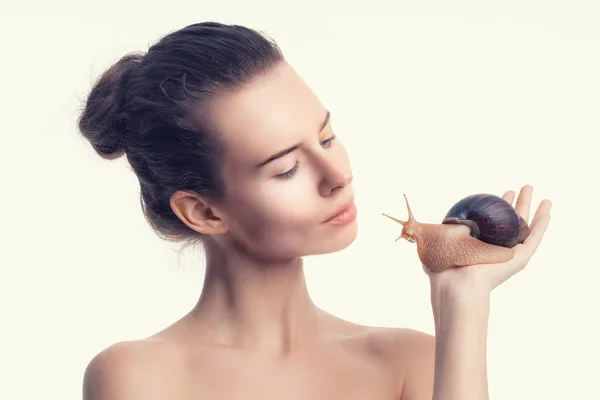 Beautiful adult girl holds giant Achatina snail on light background. Beauty treatments anti-aging — Stock Photo, Image