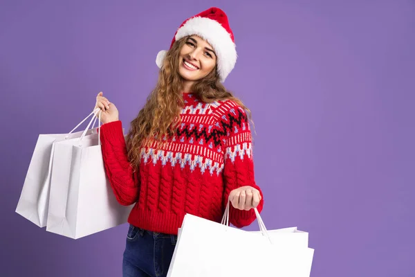 Mujer feliz sostiene bolsas de compras sobre fondo púrpura. regalos de Navidad. Venta de Navidad. Viernes Negro —  Fotos de Stock
