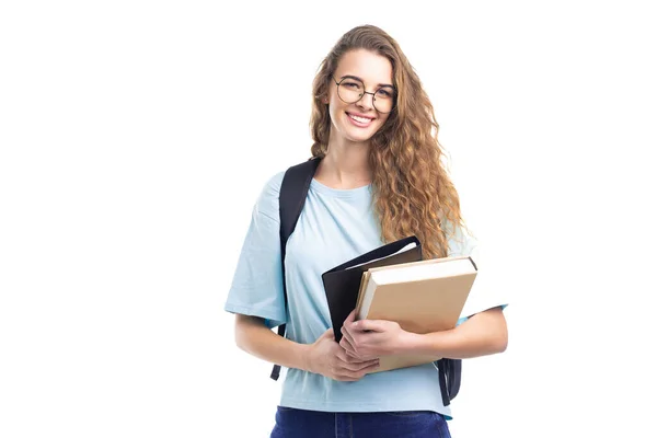 Jong lachend studentmeisje houdt boeken bij terwijl ze naar de camera kijkt. Over witte achtergrond. Onderwijs. — Stockfoto