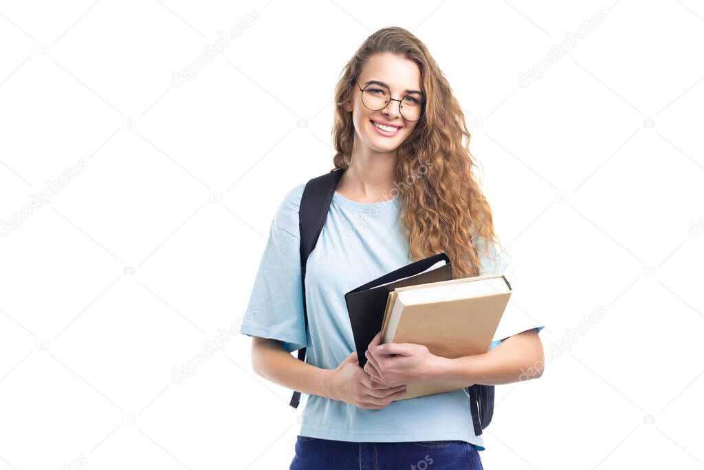 Young smiling student girl holds books while looking at camera. Over white background. Education.