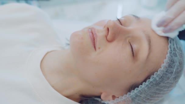 Close-up gezicht jonge vrouw die cosmetische gezichtsbehandeling ondergaat. Schoonheidstherapie. Cosmetologie huidverzorging — Stockvideo