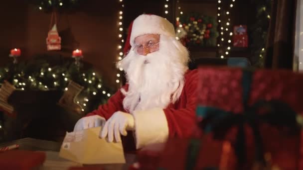 Emotional Santa Claus opening envelope with letter while sitting at the table. Christmas time — 图库视频影像