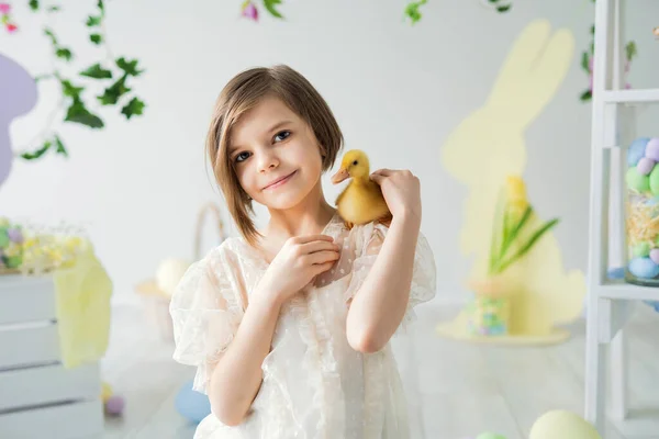 Πορτρέτο του χαμογελαστού κοριτσιού που κατέχει και επικοινωνεί με παπάκι. Πασχαλινή διακόσμηση. Καλό Πάσχα. — Φωτογραφία Αρχείου