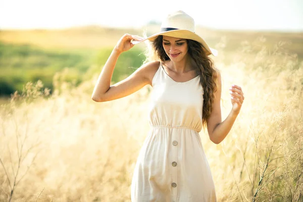 Mulher branca jovem bonita em chapéu de sol e vestido romântico que anda ao ar livre. Estilo de vida da moda — Fotografia de Stock