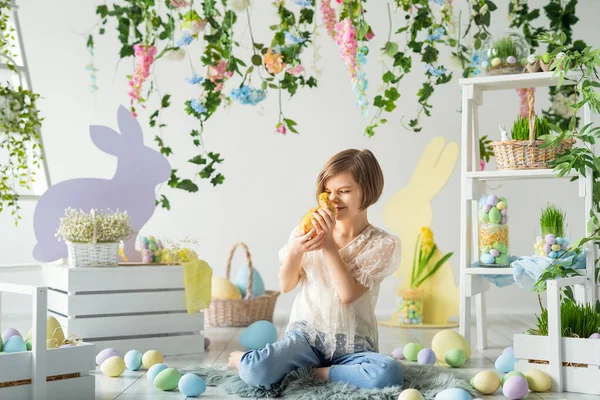 Easter composition. Happy girl plays and communicates with duckling while sits on the wooden floor — Stock Photo, Image