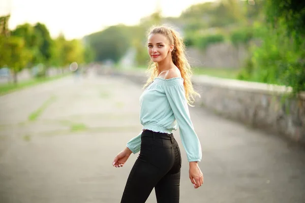 Vista trasera de la hermosa chica con estilo que posando mientras lleva en verano ropa brillante en el parque — Foto de Stock