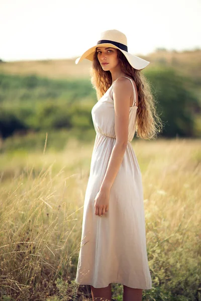 Attractive caucasian girl in sunhat and romantic dress who walks outdoors. Fashion Lifestyle — Fotografia de Stock