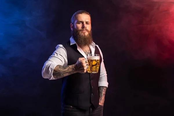 Half length of hipster bearded man who holds mug of beer looking at camera over smoke background — Zdjęcie stockowe