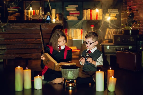 Little wizards read magic book and brew a potion . Halloween party. Cosplay Harry Potter — Fotografia de Stock