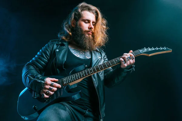 Guitar player. Rockstar bearded man plays on electric guitar isolated on black background. — Stock Photo, Image