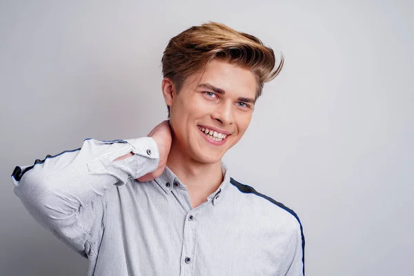 Portret van een lachende hippe jongeman die een shirt draagt terwijl hij naar de camera kijkt. Stijlvolle mannen kapsel — Stockfoto