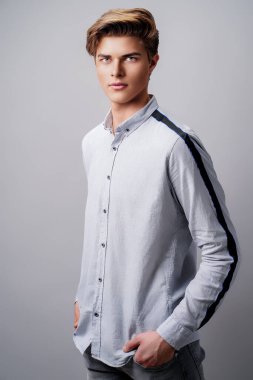 Erkek saç stili konsepti. Beyaz arka planda duran şık saç kesimli yakışıklı adam.