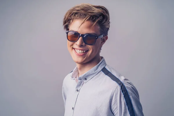 Mužský účes. Portrét hipster usmívajícího se chlapa se stylovým účesem ve slunečních brýlích. — Stock fotografie