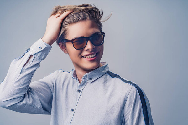 Male hairstyle concept. Portrait of hipster smiling man with stylish haircut in sunglasses. 