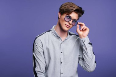 Erkek aksesuarları, optikler. Modern güneş gözlüklü ve tişörtlü hippi. Stüdyo resmi