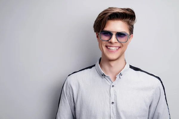 Pánské doplňky, optika. Hezký usměvavý muž v košili a moderních slunečních brýlích. Studio portrét — Stock fotografie