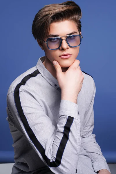 Herenaccessoires, optiek. Hipster jongeman in hemd met een stijlvolle zonnebril. Studio portret — Stockfoto