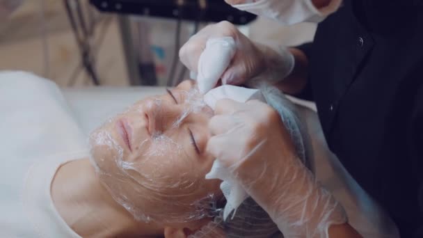 De cosmetoloog reinigt het gezicht van acne met zijn handen. Professionele huidverzorging. Gezicht schoon. — Stockvideo