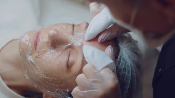 El cosmetólogo limpia la cara del acné con las manos. Cuidado profesional de la piel. Limpieza de la piel — Vídeos de Stock