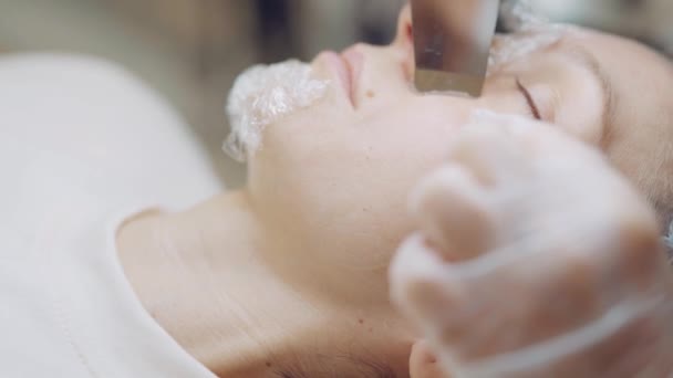 Mujer cosmetóloga profesional haciendo limpieza facial ultrasónica a paciente. Cuidado de la piel — Vídeos de Stock