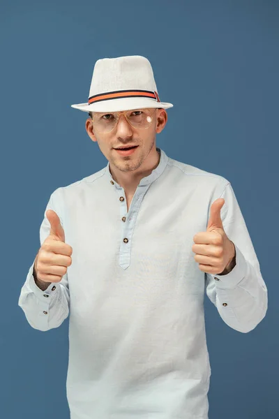 Half length of hipster man in stylish eyewear in elegant hat gesturing thumbs up colorful background — Stock Photo, Image