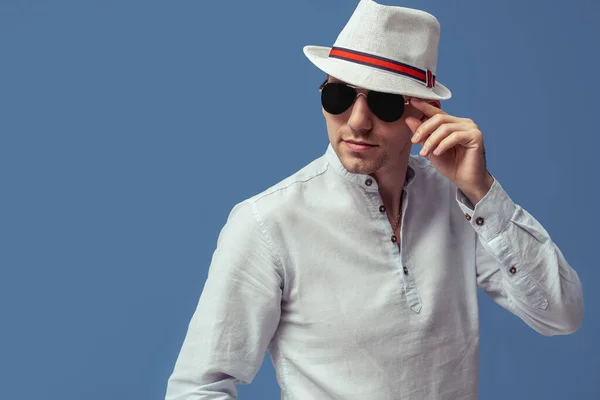 Studio portrait of hipster man who posing in sunglasses with elegant hat on colorful background — Stock Photo, Image