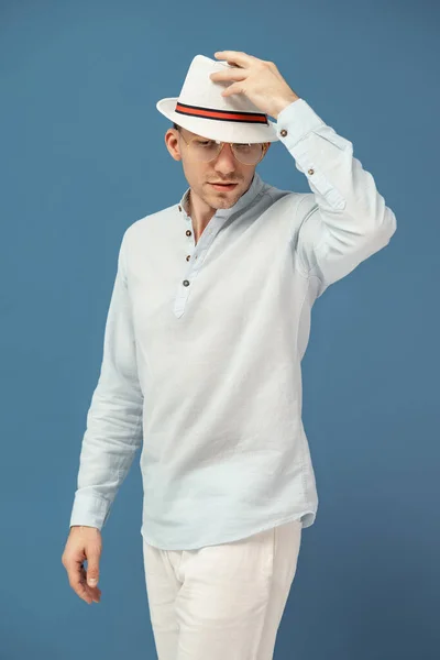 Poloviční délka stylového muže, který pózuje v moderních brýlích s elegantním kloboukem na barevném pozadí — Stock fotografie