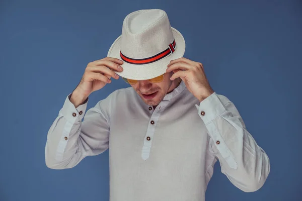 Studio portrét stylového muže, který pózuje s elegantním bílým kloboukem na barevném pozadí — Stock fotografie