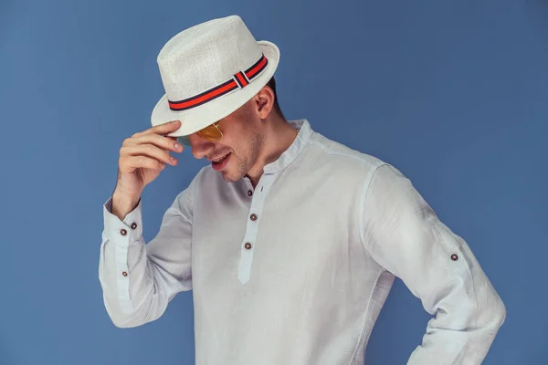 Studio portret van stijlvolle man die poseren in een zonnebril met elegante hoed op kleurrijke achtergrond — Stockfoto