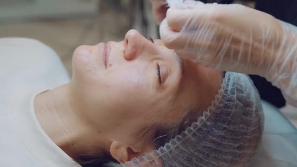 Vista lateral de una joven haciendo limpieza facial ultrasónica en salón de belleza. Cuidado de la piel — Vídeos de Stock