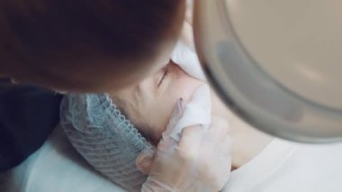 Güzellik uzmanları kızın yüzünü elleriyle temizler. Profesyonel cilt bakımı 