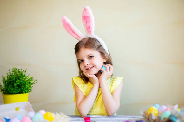 Симпатична дівчина у вухах кроликів тримає великоднє яйце в руці, дивлячись на камеру. підготовка до Великодня — стокове фото