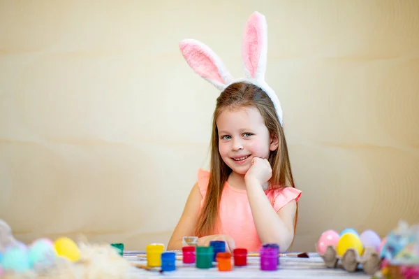 Little cute girl nosi króliczki uszy przygotowuje się do Wielkanocy malowane pisanki. Wesołych Świąt — Zdjęcie stockowe
