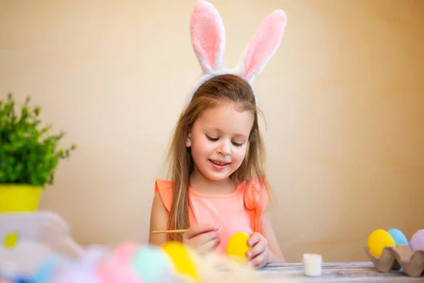 Cute dziecko w uszach króliczków przygotowuje się do Wielkanocy malowane pisanki. Wesołych Świąt — Zdjęcie stockowe