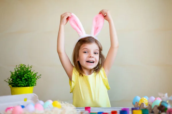 Śmieszne przygotowania do Wielkanocy. Wielkanoc malowane jaja. Słodka dziewczynka nosi królicze uszy. Koncepcja wielkanocna — Zdjęcie stockowe