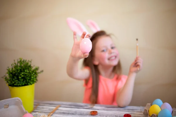 Cute girl w uszy Easter Bunny malowanie pisanek w domu przygotowuje się do Wielkanocy. Skupienie selektywne — Zdjęcie stockowe