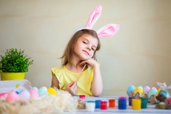Cute little girl w króliczki uszy przygotowane do Wielkanoc malowane pisanki w domu. Wesołych Świąt — Zdjęcie stockowe