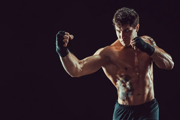 Ritratto di pugile aggressivo che allena e pratica montanti su sfondo nero. Concetto sportivo — Foto Stock